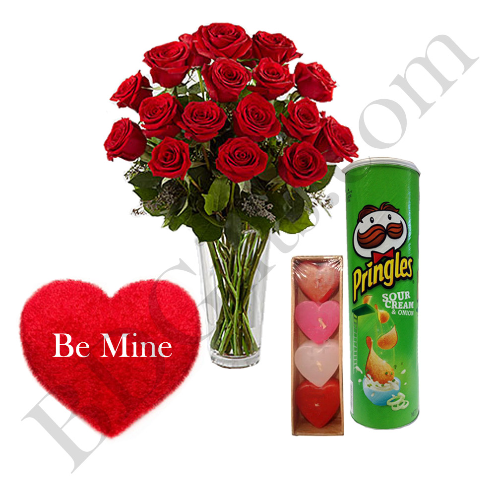 red roses in vase with chips, candles and heart shape pillow